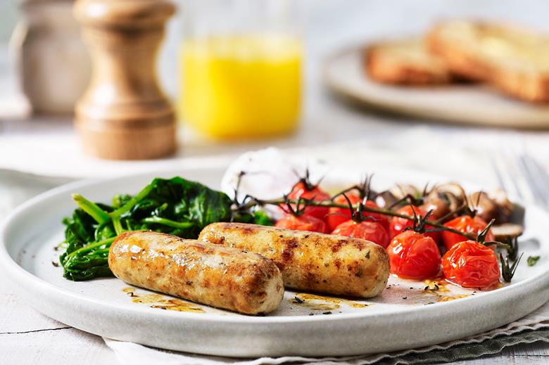 Sausages, tomatoes and spinach on a plate.