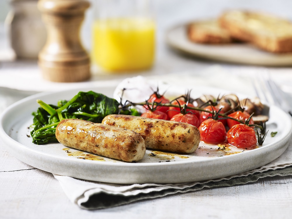 Sausages, tomatoes and spinach on a plate.